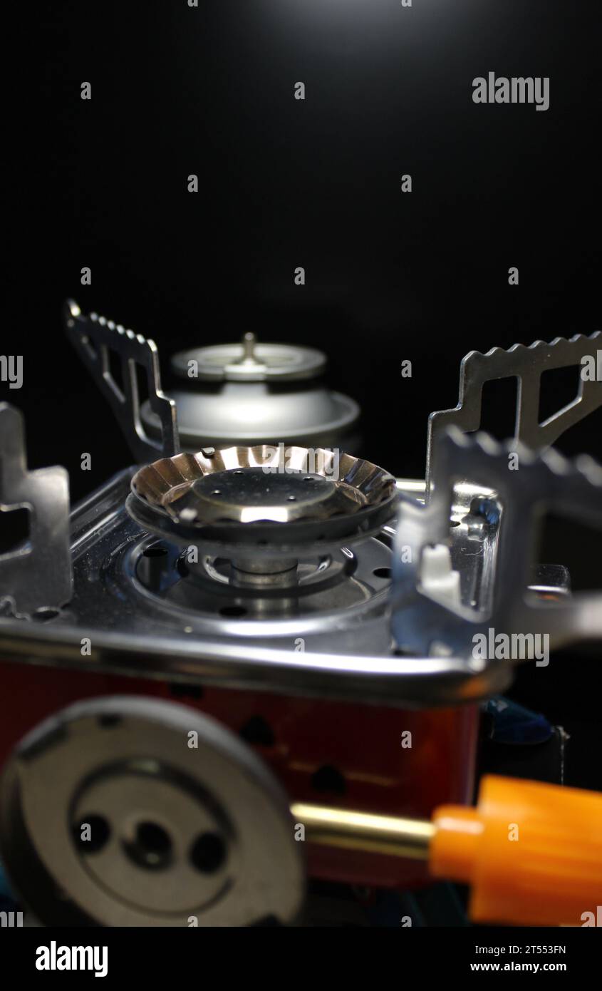 Valve and burner of a portable gas stove in front of open gas cartridge