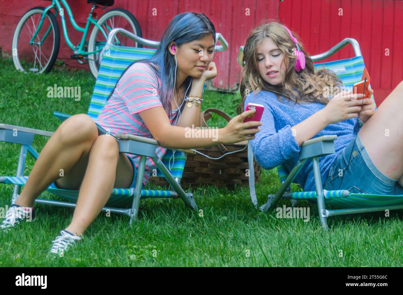 Teen girls together on phones having fun Stock Photo