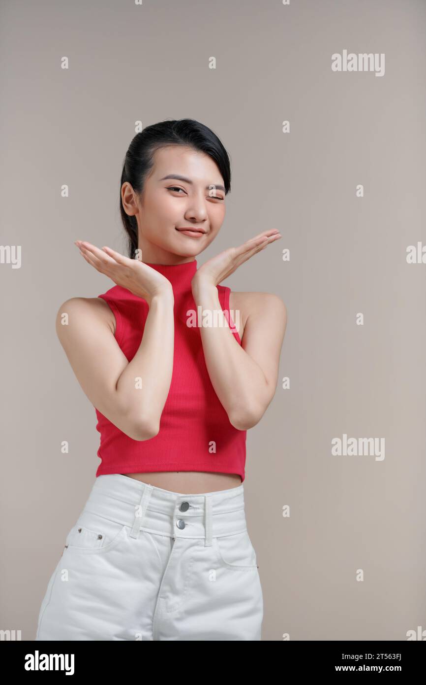Happy dreamy young asian woman holding hands near head, being concentrated on pleasant thoughts, smiling, Stock Photo