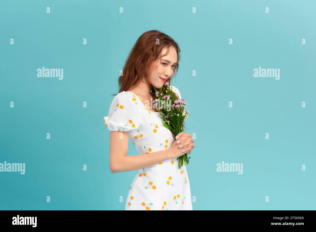 Image of happy woman in elegant dress and straw hat holding flowers ...
