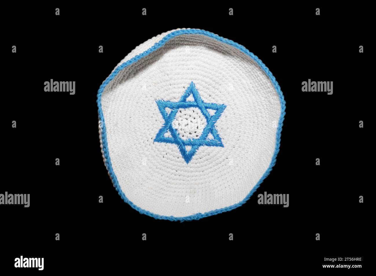 A knitted version of the kippa, small circular headgear of the Jews with a blue Star of David, hexagram, on a white background, studio photograph Stock Photo