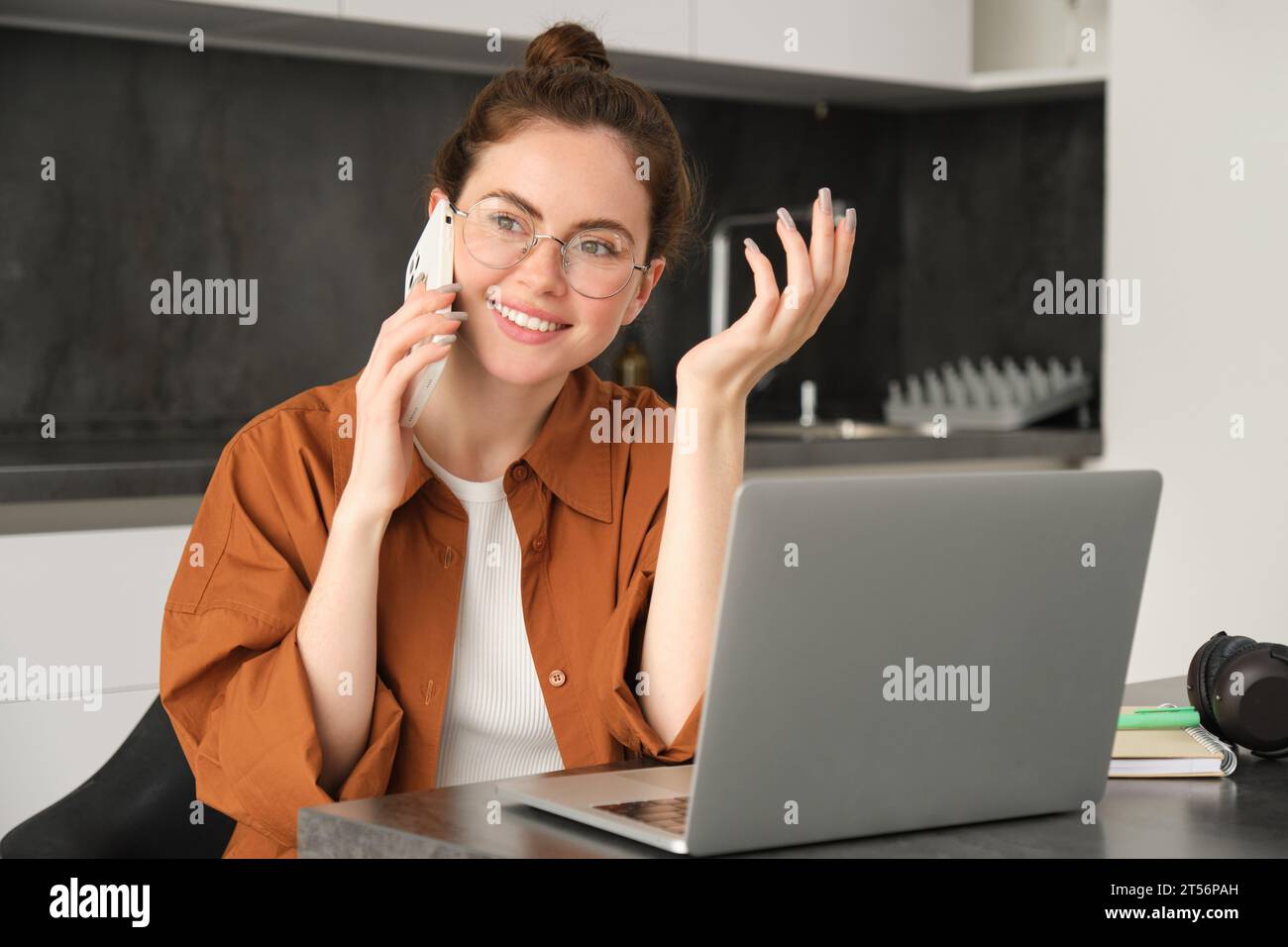 Portrait of young woman at home, doing online shopping. Businesswoman has own start-up making a phone call, has conversation with client, saleswoman t Stock Photo