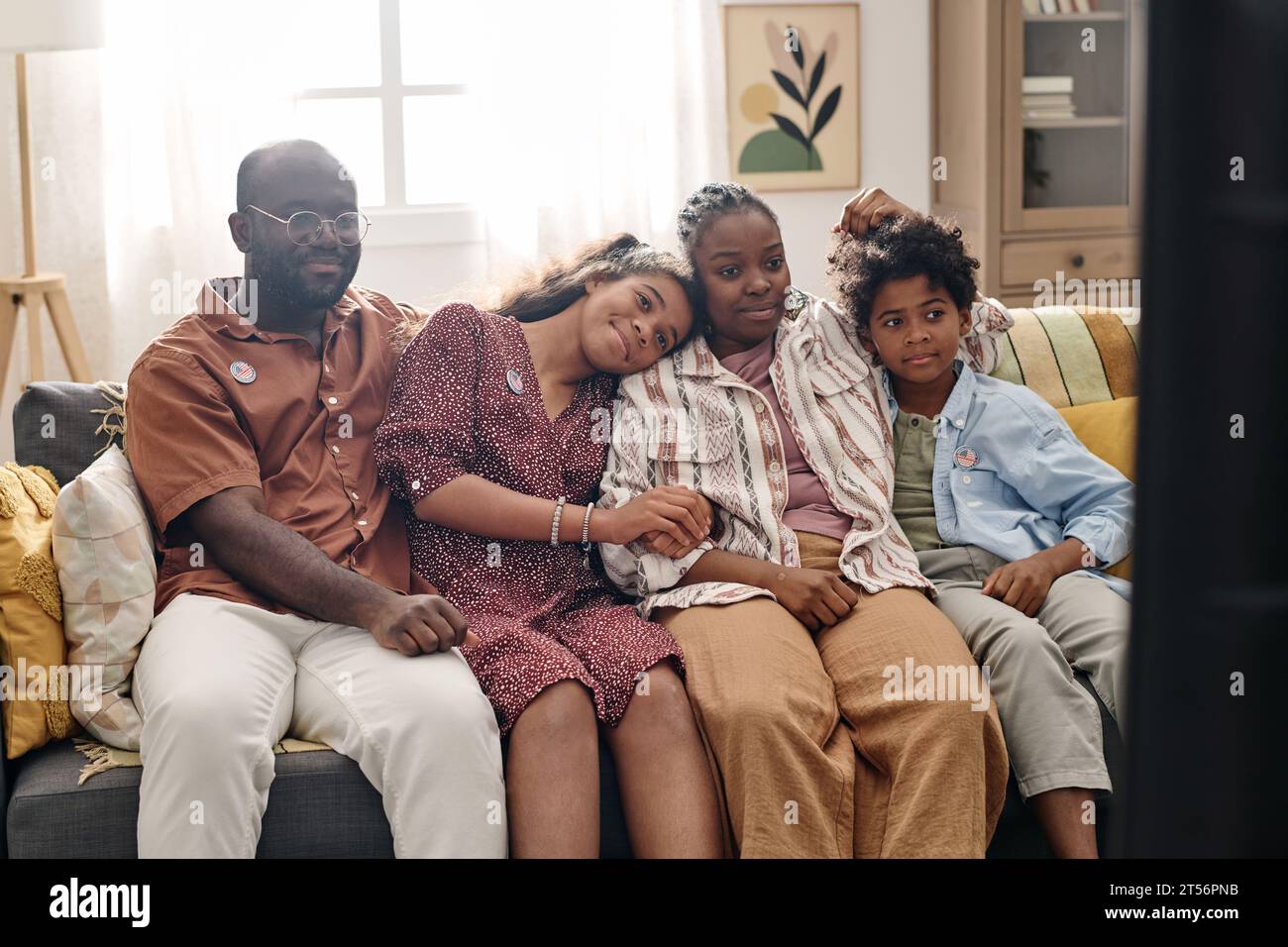 Happy Black family resting on couch at home and watching tv show Stock ...