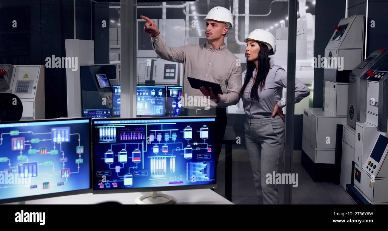 Factory Engineers In Helmets. Checking Industrial Facility Stock Photo