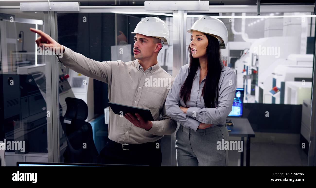 Factory Engineers In Helmets. Checking Industrial Facility Stock Photo