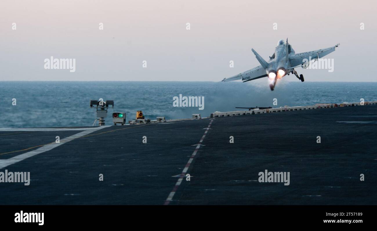 US Navy An F18C Hornet from the Golden Dragons of Strike Fighter Squadron (VFA) 192 launches off the flight deck of the Nimit.jpg Stock Photo