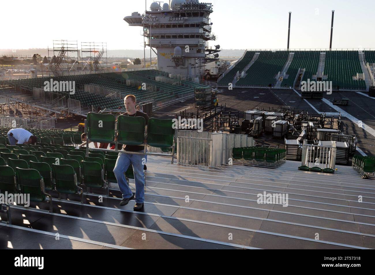 US Navy Civilian contractors install bleacher seats as workers