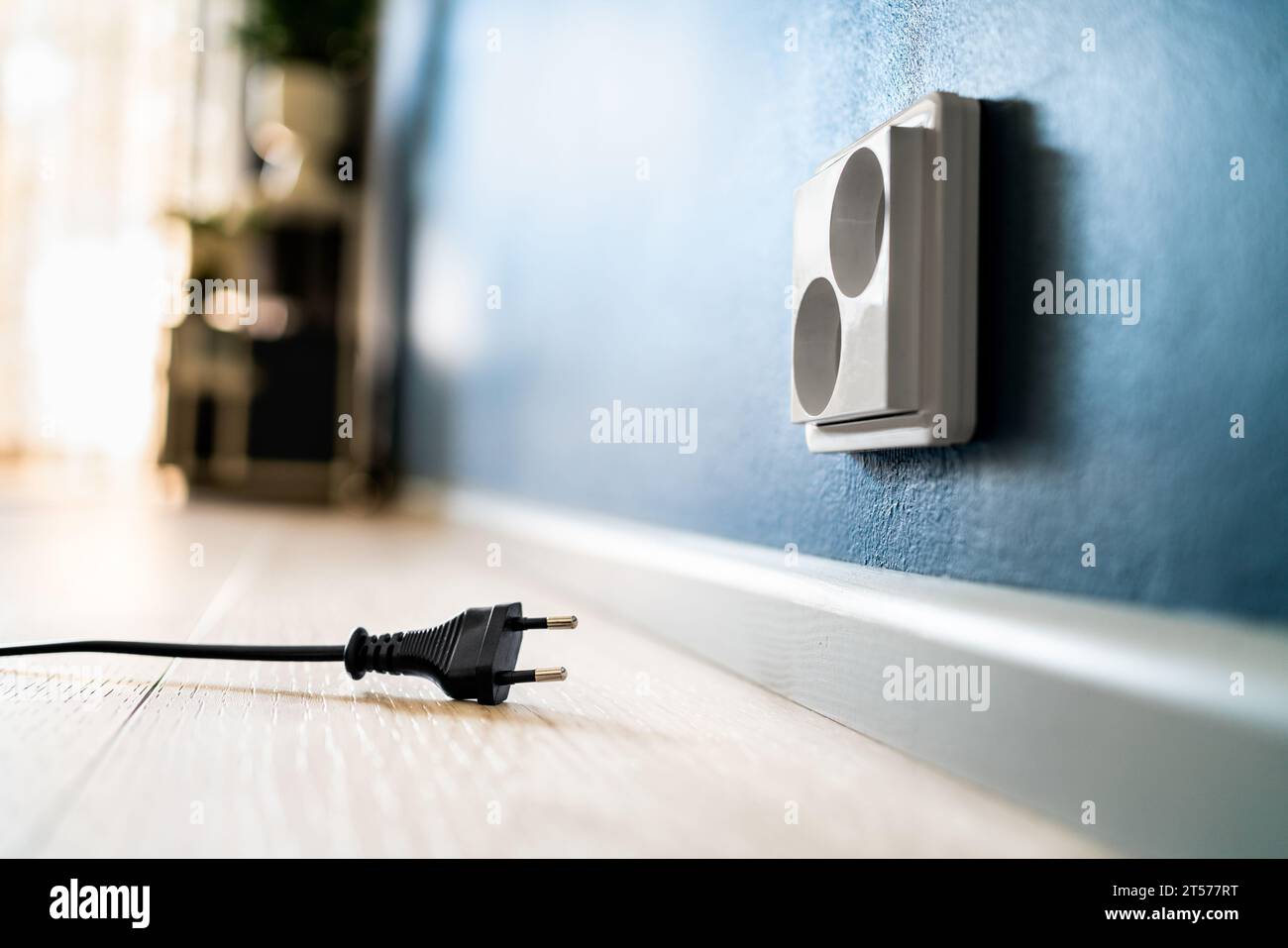 Socket and power outlet. Electric plug. Cable unplugged from wall. Wire and cord. Electricity off. Energy consumption, crisis or saving. Stock Photo