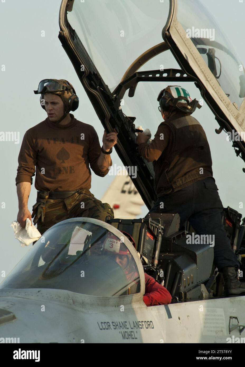 US Navy Sailors clean the canopy of an F18F Super Hornet from the Black Aces of Strike Fighter Squadron (VFA) 41 aboard the N.jpg Stock Photo