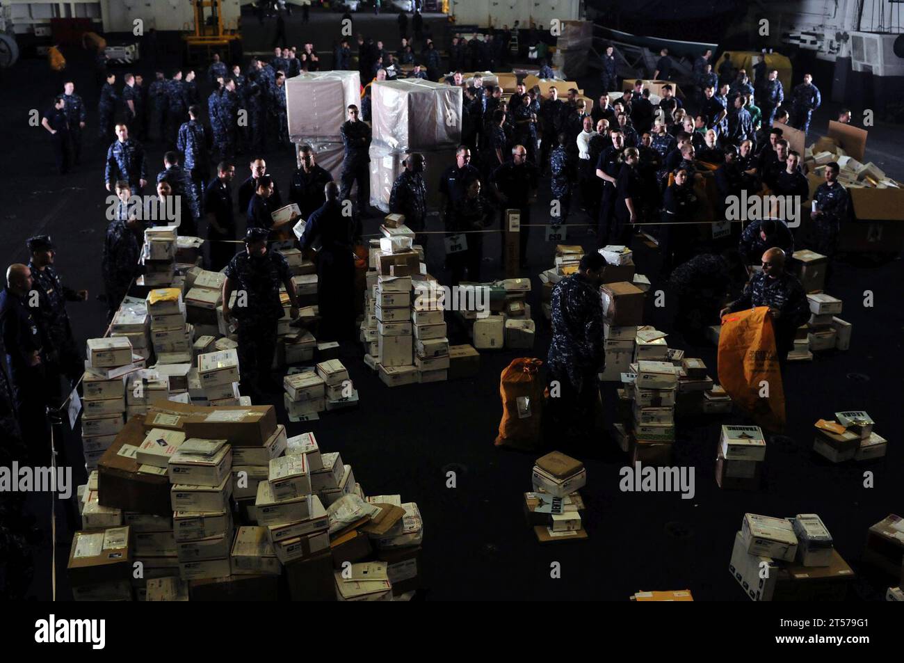 US Navy Sailors line up for their packages during mail call aboard the ...