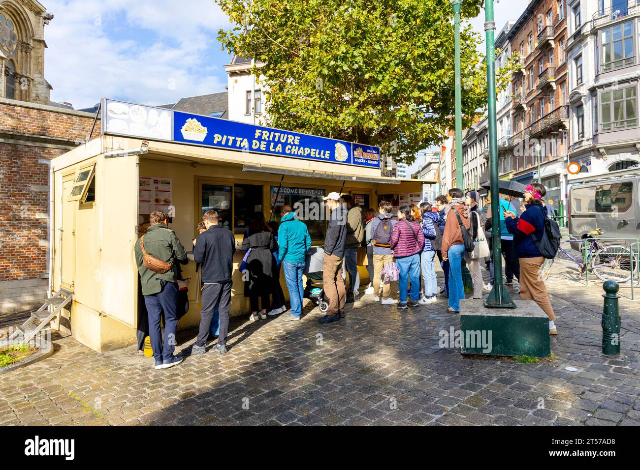 People queuing to get Belgian fries at the Friture Pitta De La Chapelle kiosk, Marollen, Brussels, Belgium Stock Photo