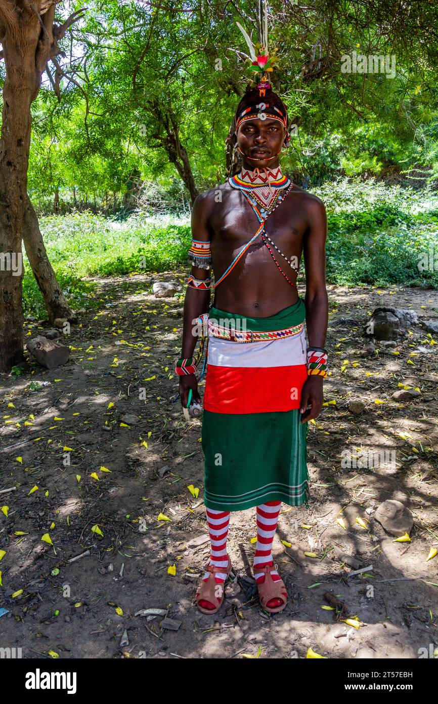 SOUTH HORR, KENYA - FEBRUARY 12, 2020: Samburu tribe young man wearing a colorful headpiece made of ostrich feathers after his circumcision ceremony. Stock Photo