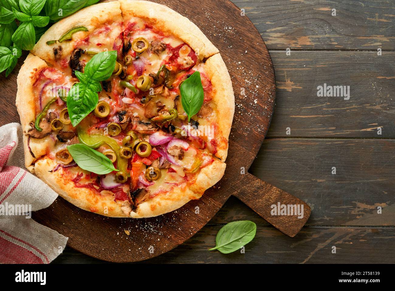 Homemade pizza. Traditional neapolitan pizza with olives, peppers, onions and mushrooms on wooden table backgrounds. Italian Traditional food. Top vie Stock Photo
