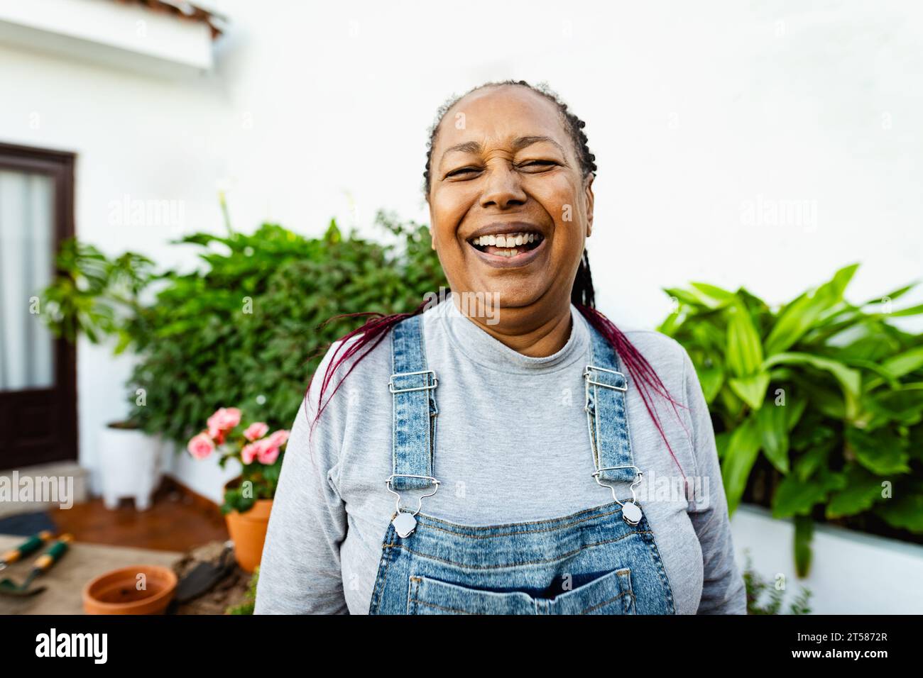 Happy African senior woman gardening at home Stock Photo
