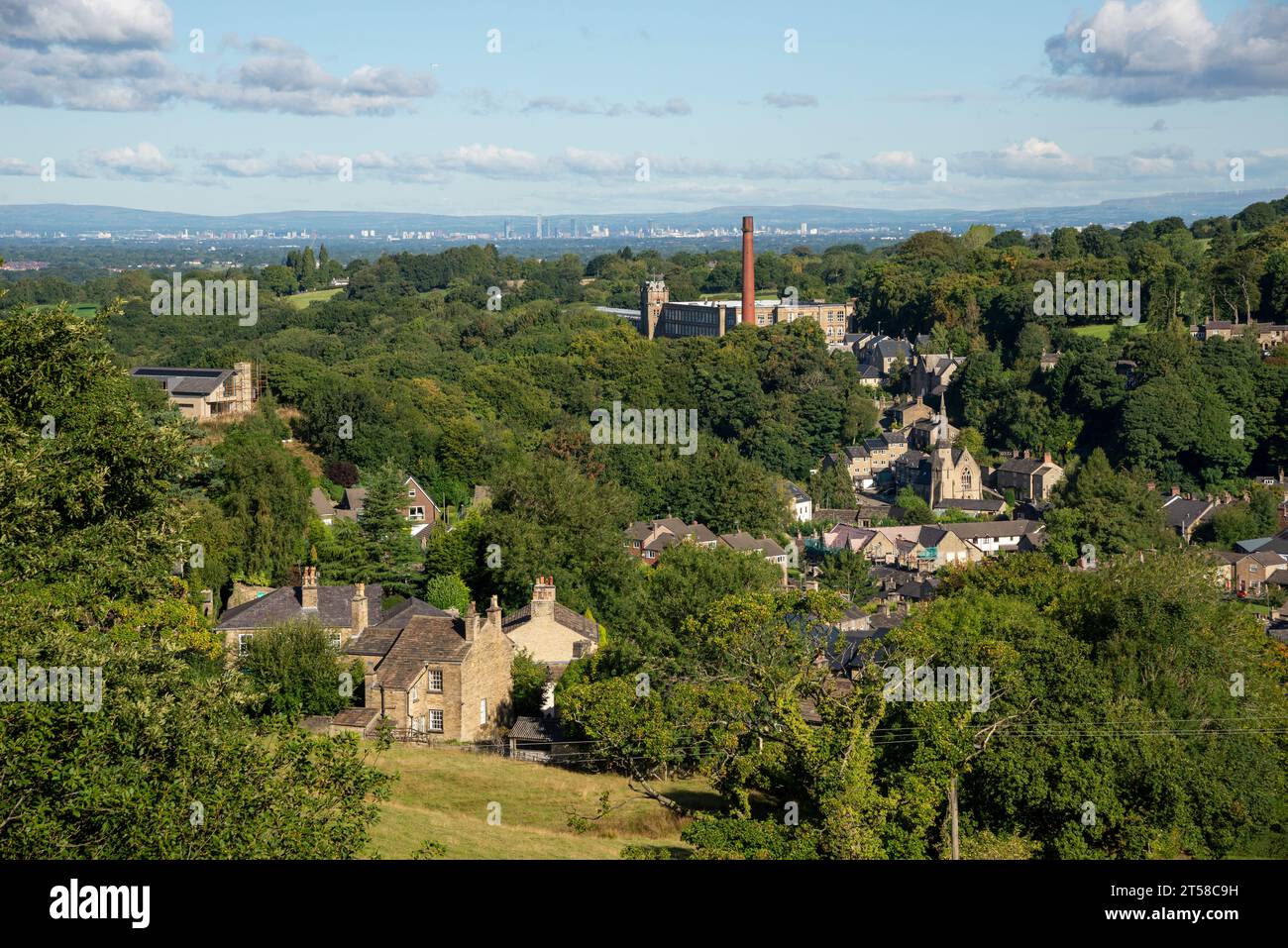 Clarence Mill in Bollington near Macclesfield, Cheshire, England. The city of Manchester in the distance. Stock Photo