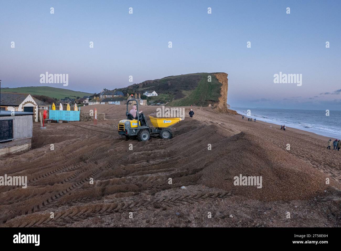 West Bay, Dorset, UK. , . Locals work into the late afternoon repairing the flood defences which were breached by Storm Ciaran at West Bay on the Dorset Coast Credit: Tom Corban/Alamy Live News Stock Photo