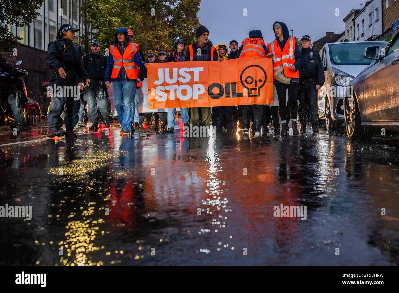 London, UK. 3rd Nov, 2023. The slow walking road block sets off from bethnal green as heavy rain falls - Just Stop Oil continue their climate protest with an action in East London. They demand that, in order to stop climate change, no new licences should be granted for fossil fuel extraction. Credit: Guy Bell/Alamy Live News Stock Photo