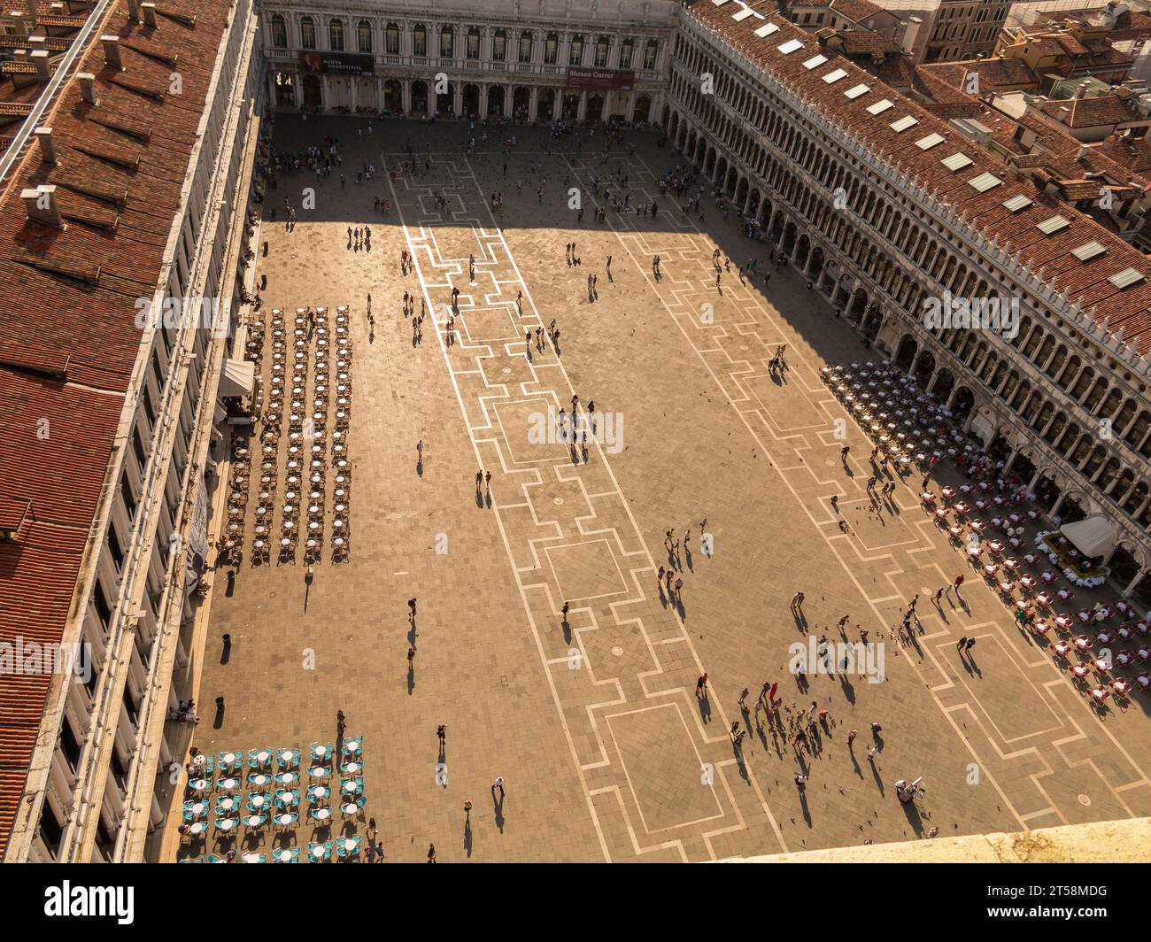 Bird's eye view taken from the Campanile of St. Mark's Square in Venice, Italy. Below we see the café terraces on the palace and the tourists wanderin Stock Photo