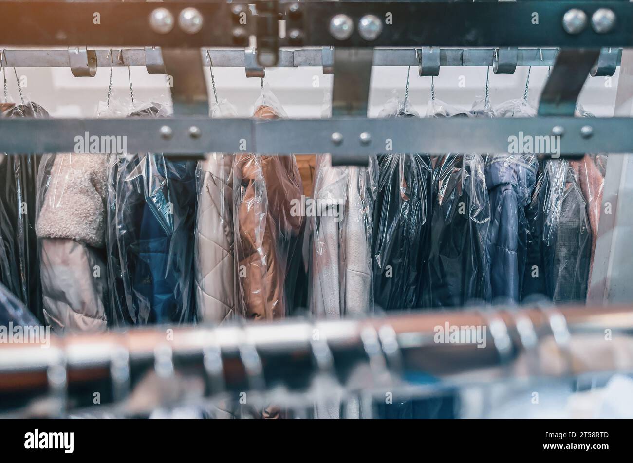 Clean clothes on hangers in dry cleaners. Conveyor with hangers of cleaned items Stock Photo Alamy