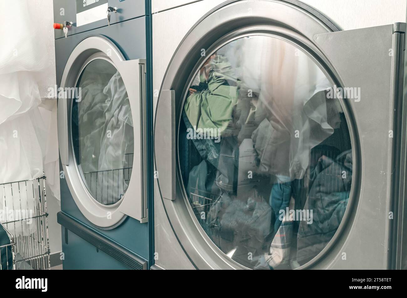 Dry cleaning dryer. Two dryers loaded with clothes are operating in dry