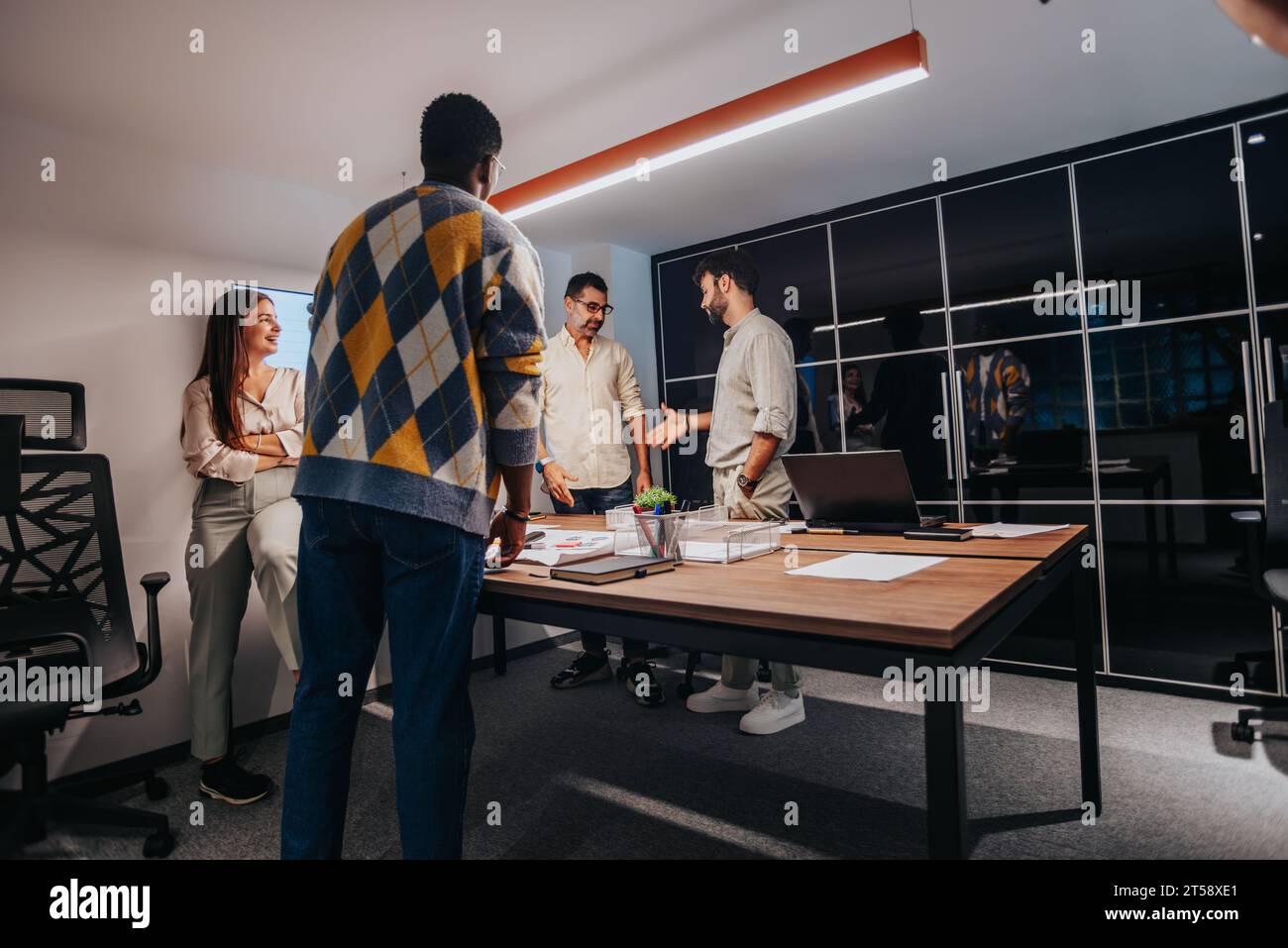 Multiracial Team of Architects and Engineers Collaborating on Architectural Blueprint in Board Room Stock Photo