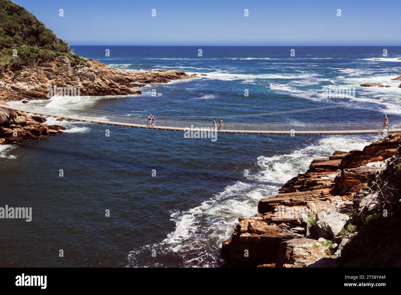 People walk across the suspension bridge in Storms River near Port