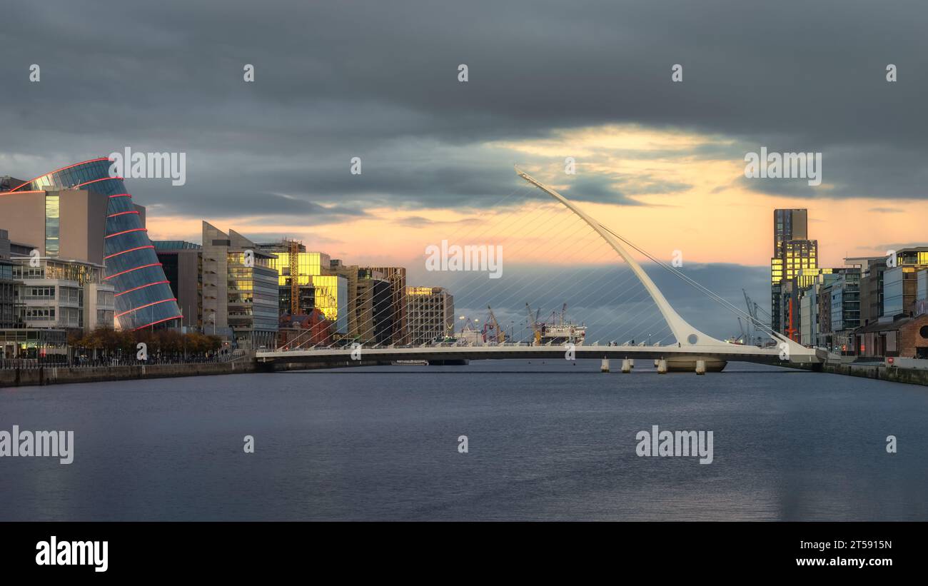 Beautiful harp shaped Samuel Beckett bridge over Liffey River, surrounded by modern convention canter, office and apartment buildings, Dublin, Ireland Stock Photo