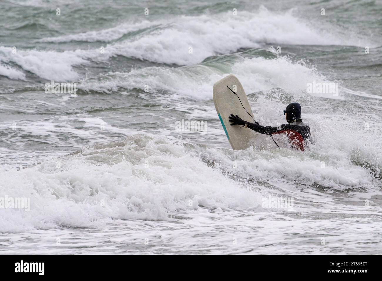 Croatia, Split, 031123. The stormy south changed to a southwesterly wind and created large waves that cause problems in maritime traffic and floods due to rising sea levels. In the photo: a brave surfer tries to overcome big waves along the coast of Bacvica. Photo: Tom Dubravec/CROPIX Split CROATIA Copyright: xxTomxDubravecx jugo lebicada bacvice2-031123 Credit: Imago/Alamy Live News Stock Photo