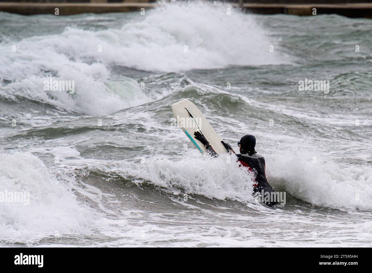 Croatia, Split, 031123. The stormy south changed to a southwesterly wind and created large waves that cause problems in maritime traffic and floods due to rising sea levels. In the photo: a brave surfer tries to overcome big waves along the coast of Bacvica. Photo: Tom Dubravec/CROPIX Split CROATIA Copyright: xxTomxDubravecx jugo lebicada bacvice1-031123 Credit: Imago/Alamy Live News Stock Photo