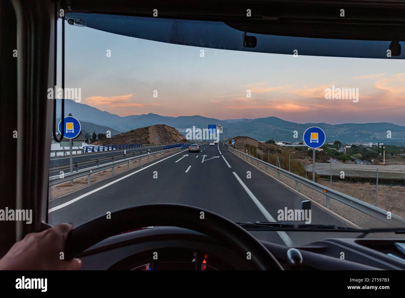 View from inside a truck of some traffic signs indicating that the highway on which it circulates is authorized for the transport of dangerous goods. Stock Photo