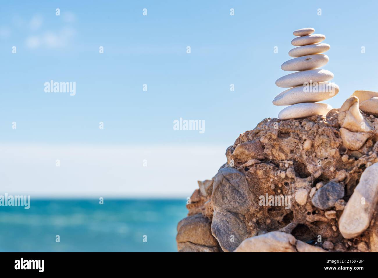 Pyramid of white stones facing the sea, apachetas, concept of yoga and personal balance, offering to the deity in some towns, stability in the Zen phi Stock Photo
