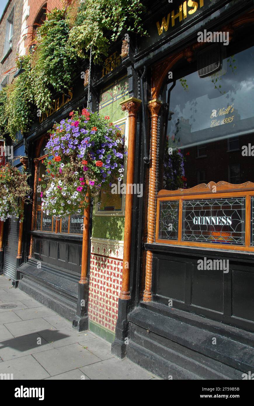 O'Neill's Vicorian Pub established in Dublin in 1885 is bedecked with hanging baskets;stained glass window; Stock Photo