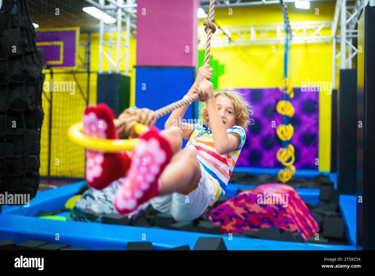 Child jumping in trampoline park. Bounce fun on kids birthday party