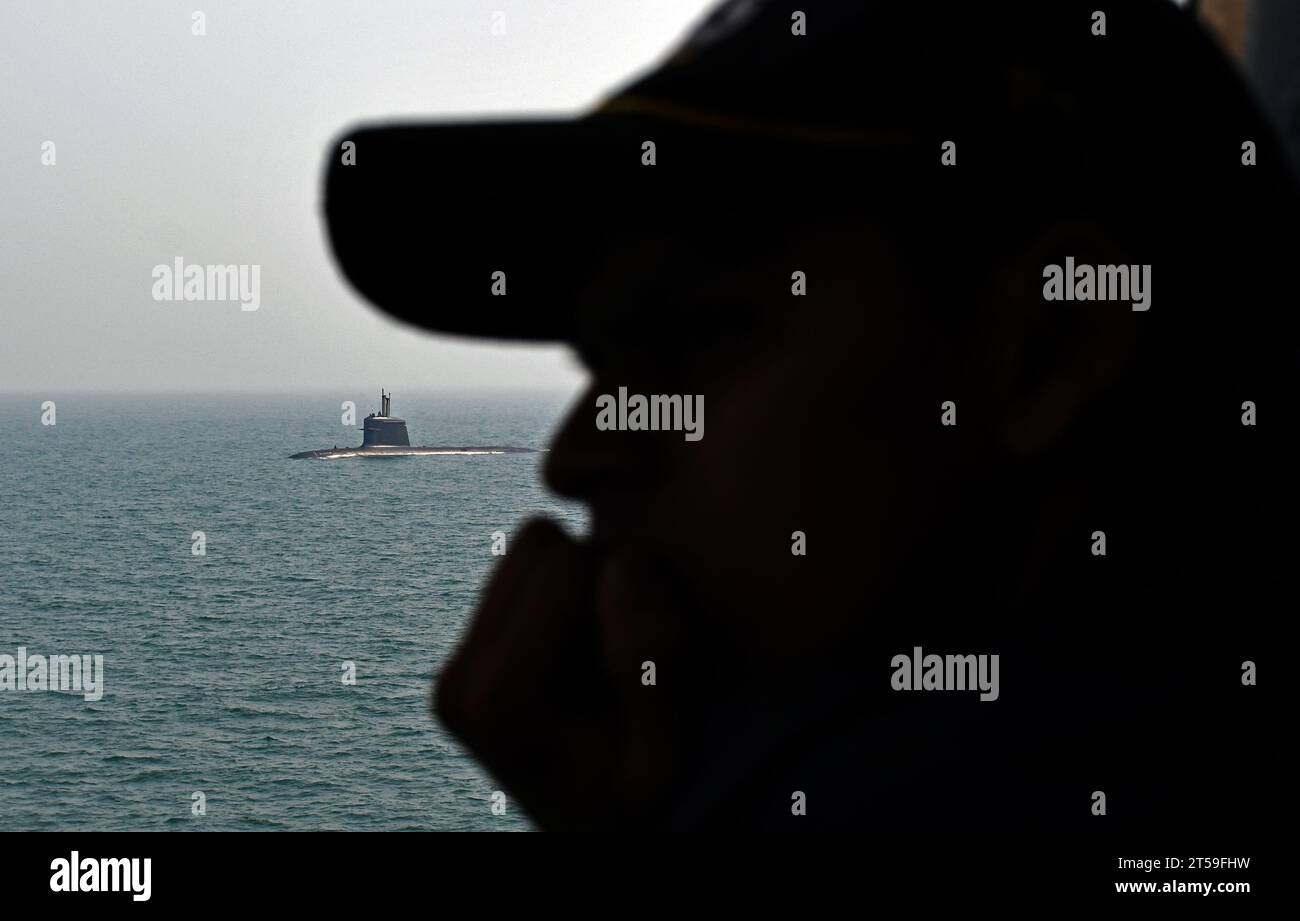 Mumbai, India. 03rd Nov, 2023. A navy personnel (silhouetted) watch submarine INS 'Kalvari' passing by from warship INS Beas during a media day at sea event in Mumbai. Credit: SOPA Images Limited/Alamy Live News Stock Photo