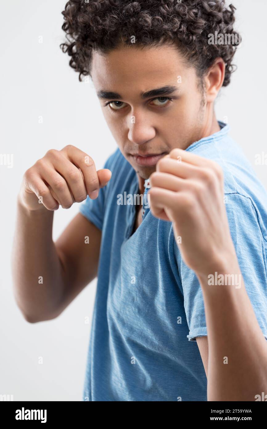 Poised in combat, the man's determined gaze and clenched hands reveal his intent Stock Photo