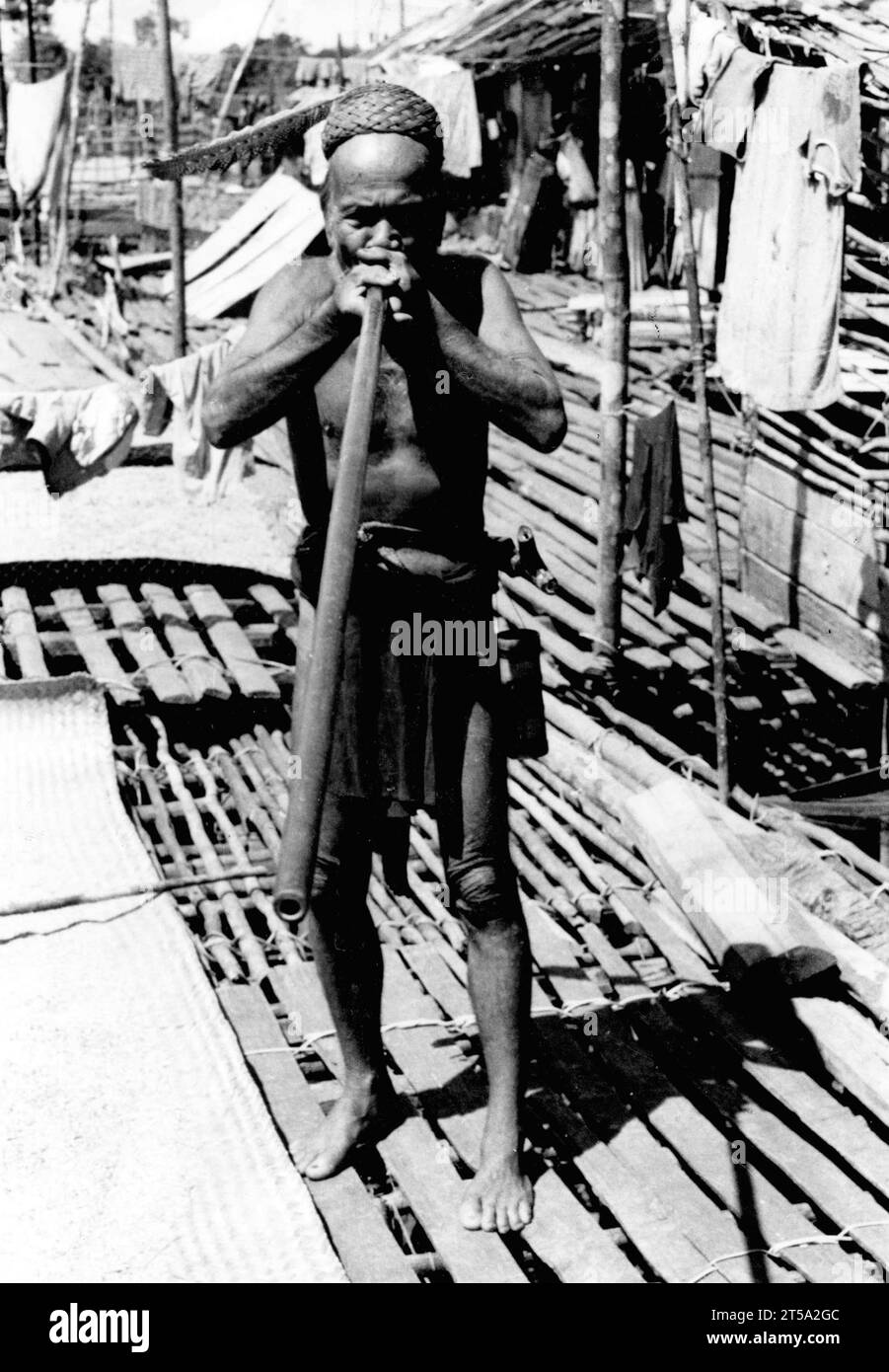 Old Dyak with his blowpipe Sarawak, East Malaysia, 1974. He wears a cap made of armdaillo scales