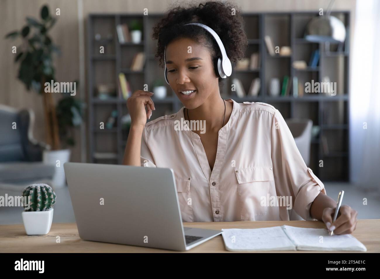 Happy gen Z African student girl in headphones watching webinar Stock ...