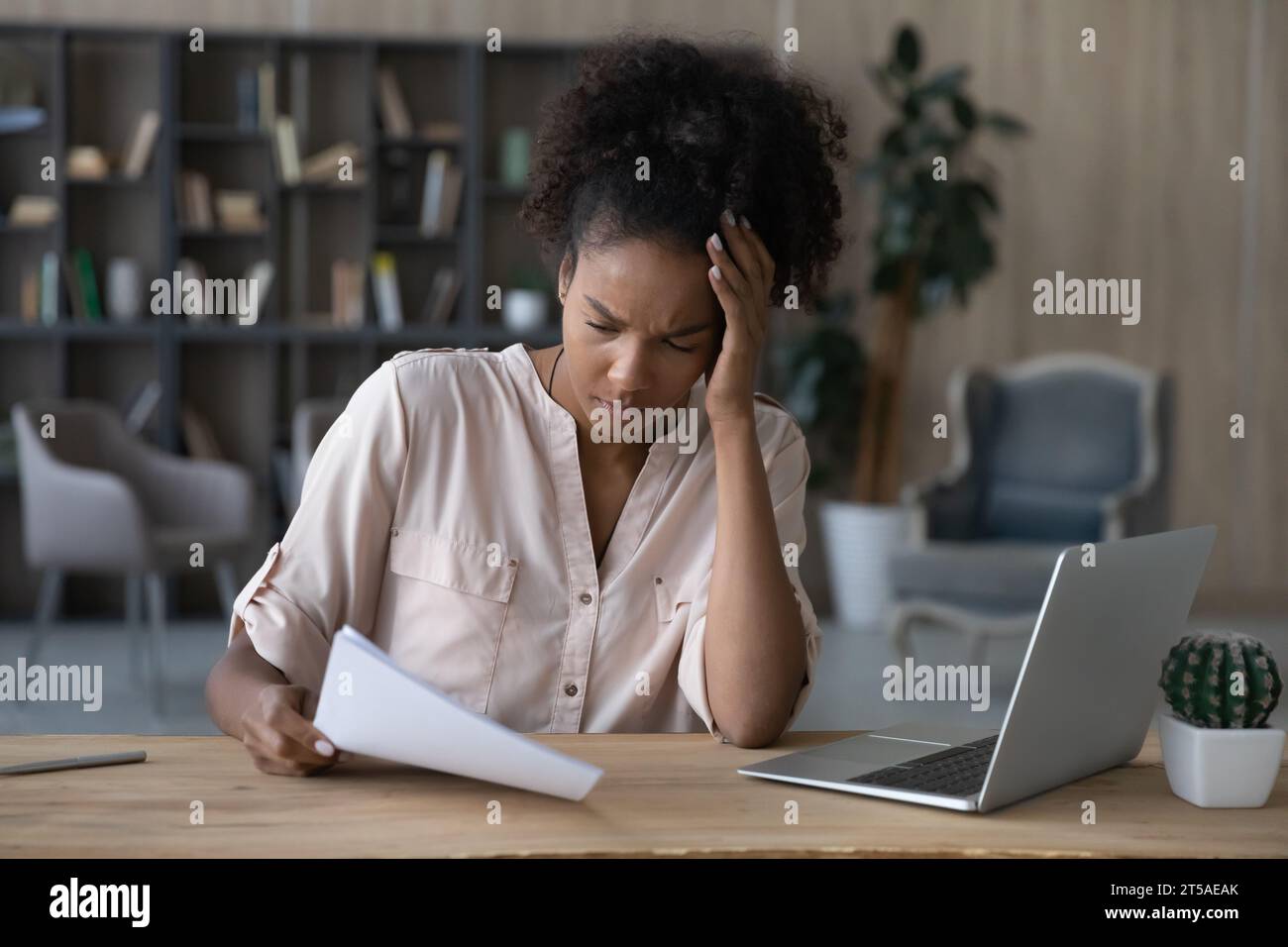 Shocked young African American woman getting document with bad news Stock Photo
