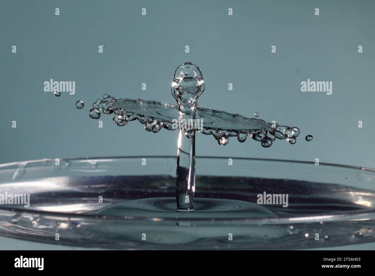 two drops of water collide and cause a splash with crown and spikes ...