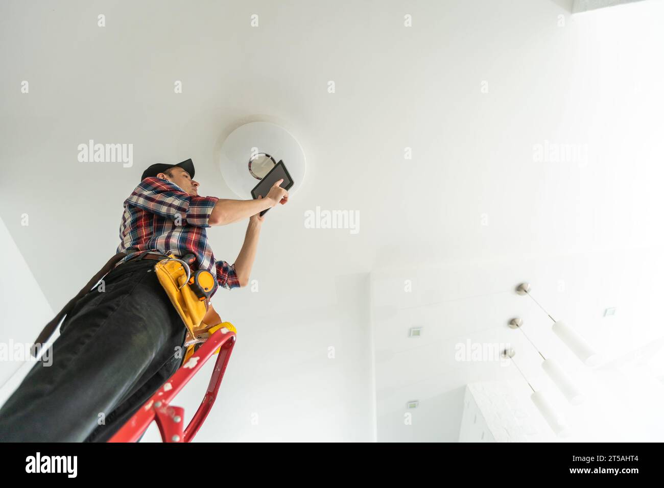 Electrician man worker installing ceiling lamp Stock Photo - Alamy