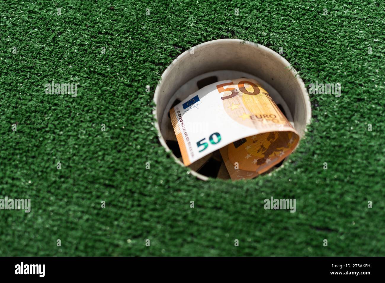 Mini Golf club, money on the artificial grass Stock Photo