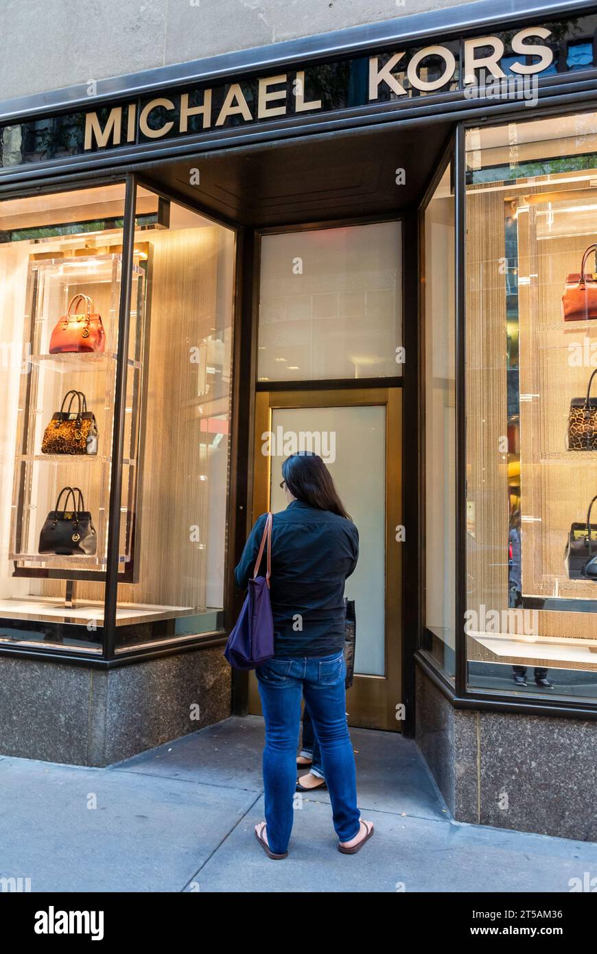 New York City, NY, USA, Michael Kors, Woman Standing in Front, Luxury Fashion Store Front, Fifth Ave., WIndow Display, Women's Bags Stock Photo