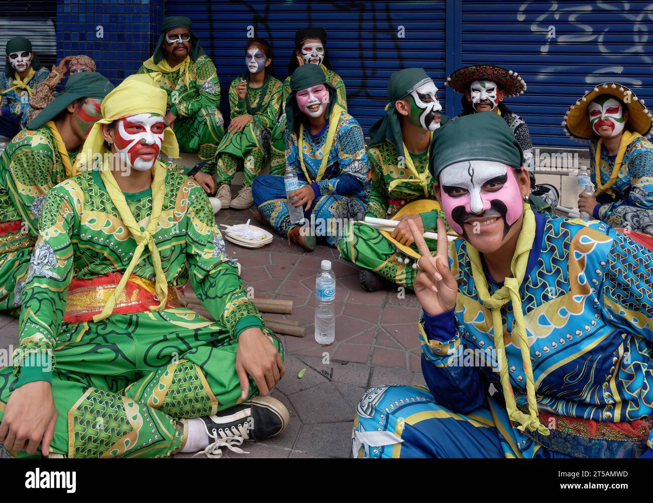 Members of a Lion Dance troupe with exotic dress and colorfully painted faces waiting for their performance at a Taoist shrine in Bangkok, Thailand Stock Photo