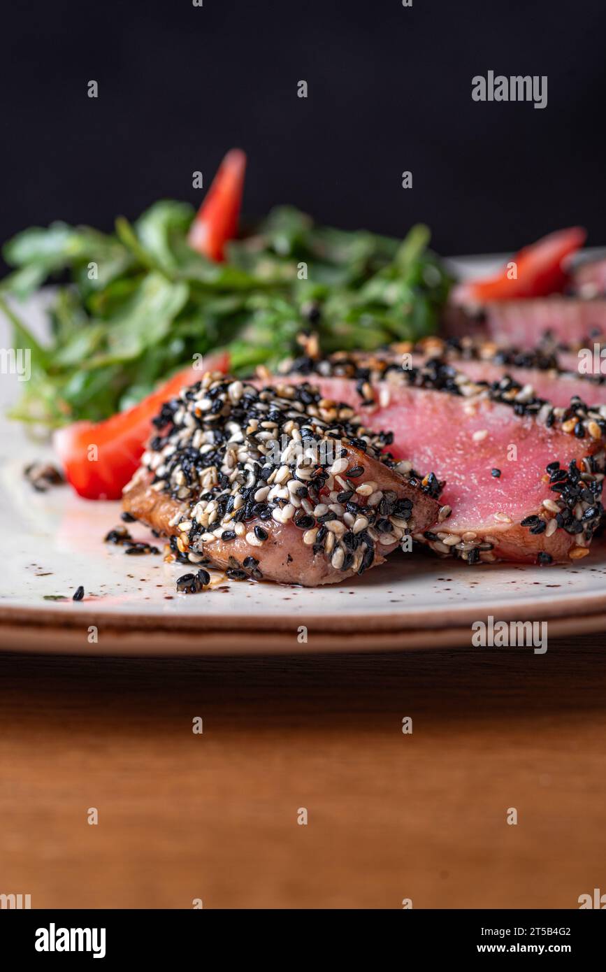 Tuna tataki in sesame with quinoa and spinach. Healthy food, closeup