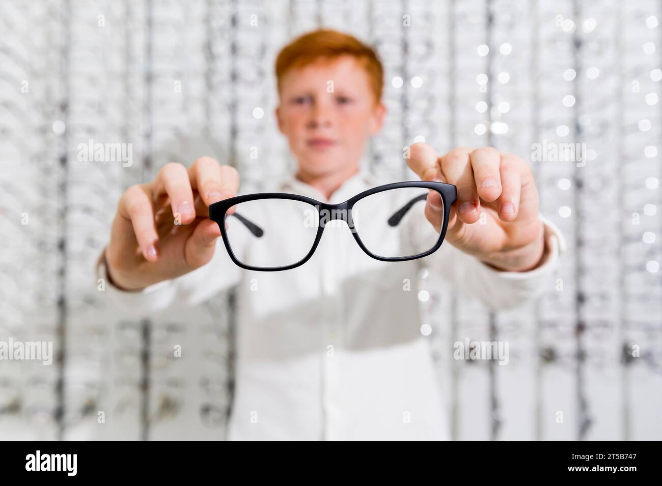 Cute boy holding black spectacle optics store Stock Photo