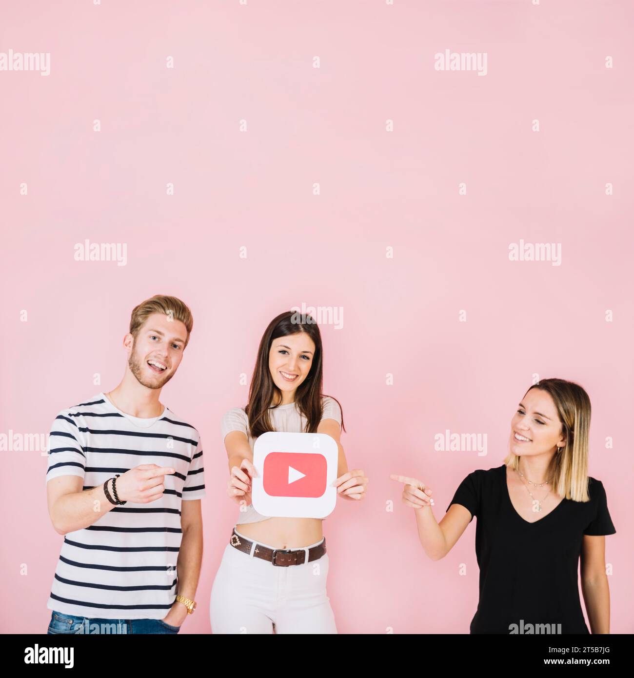 Happy man woman pointing their friend showing play icon Stock Photo - Alamy