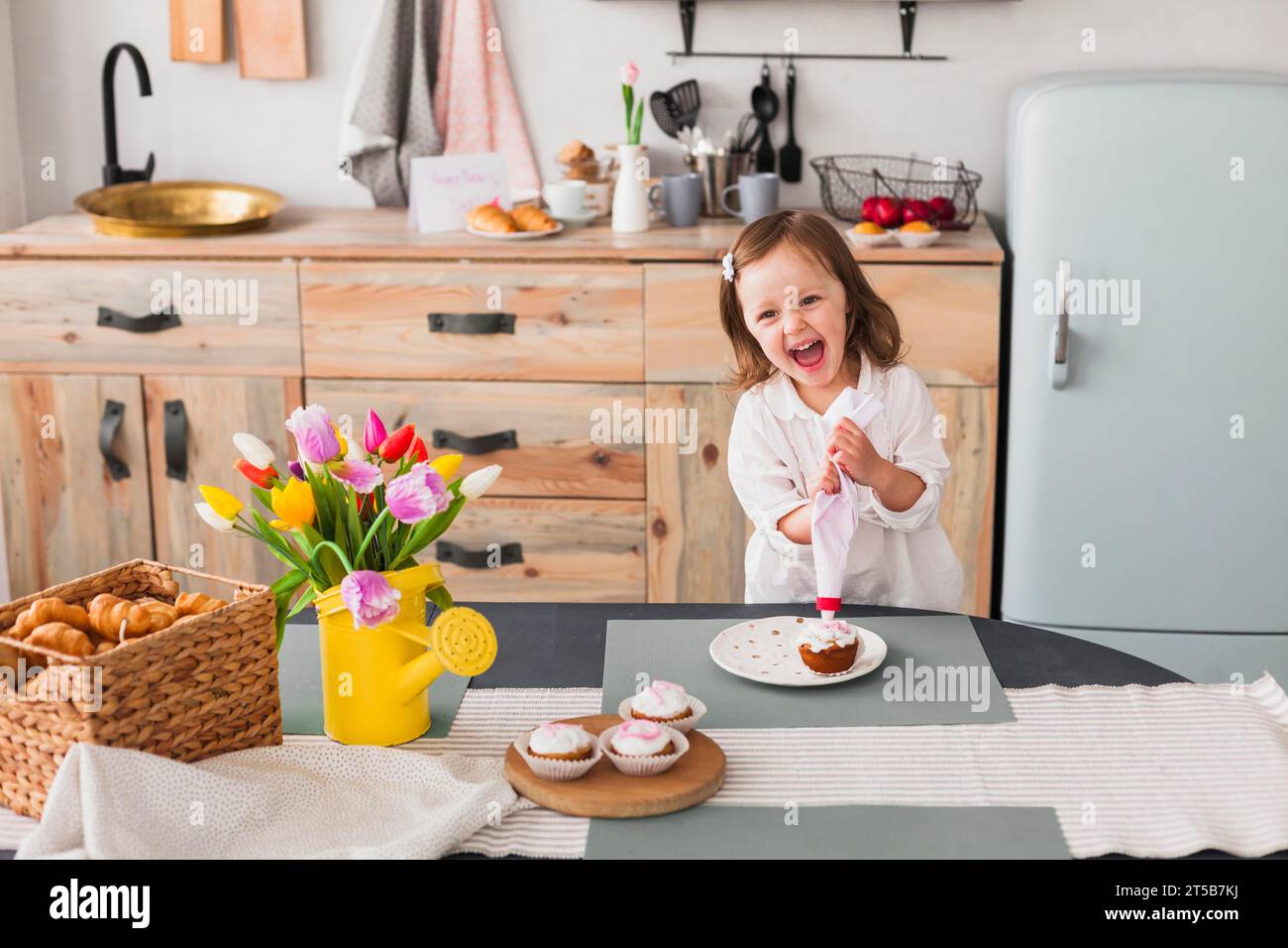 Happy little girl making cupcake Stock Photo