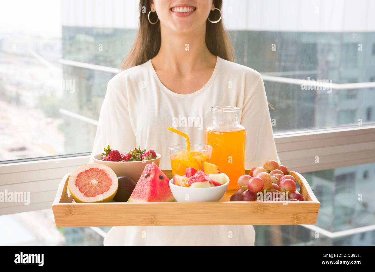 Midsection woman holding wooden tray with many fruits juice Stock Photo