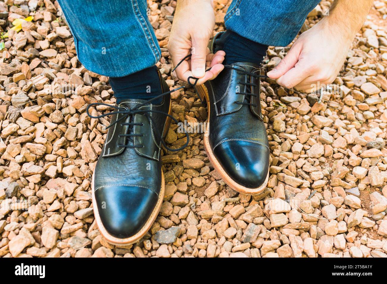 Elevated view man s foot pebble tying shoelace Stock Photo