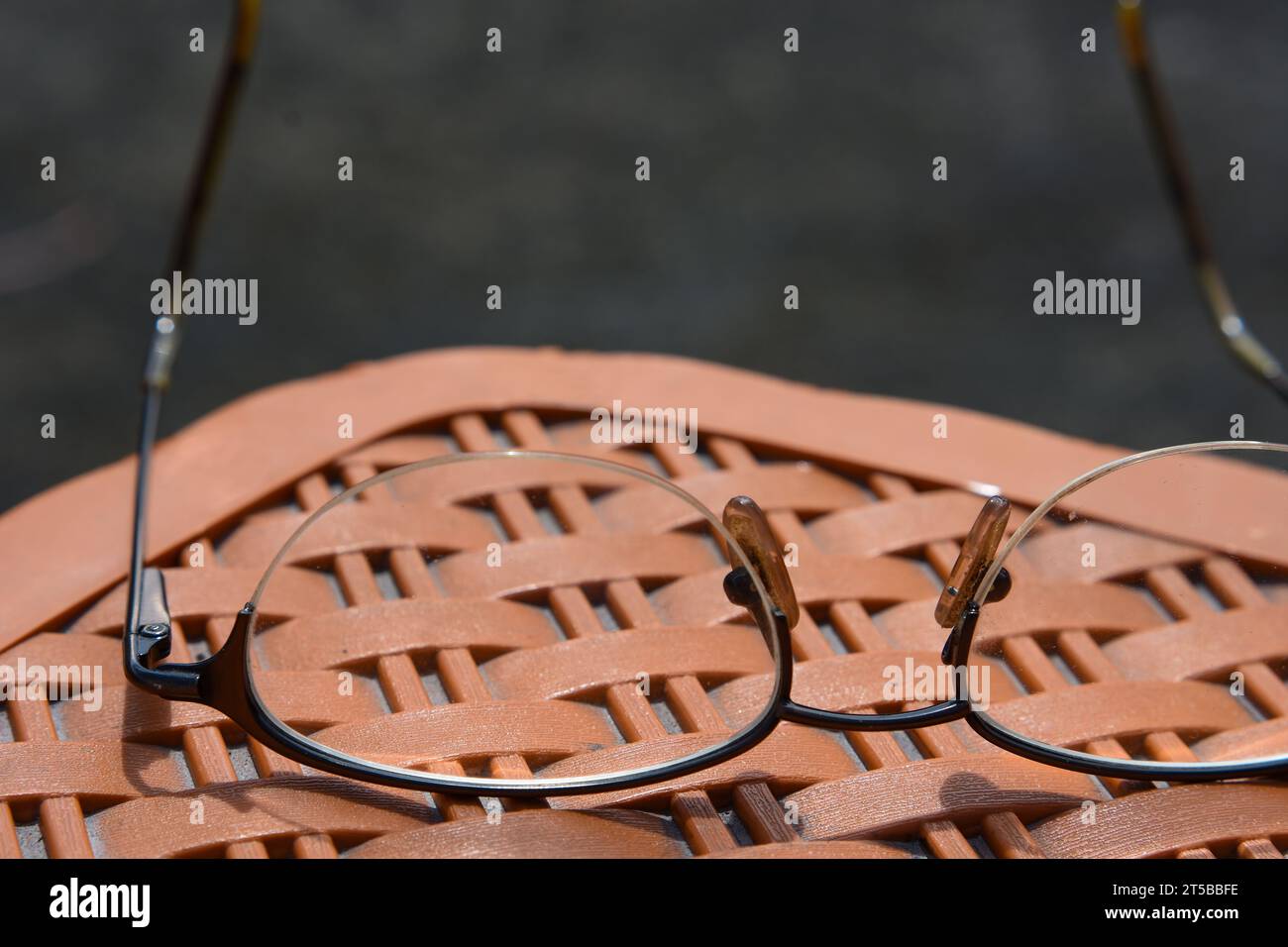 Classic metal frame Spectacles lying down on plastic stool Stock Photo